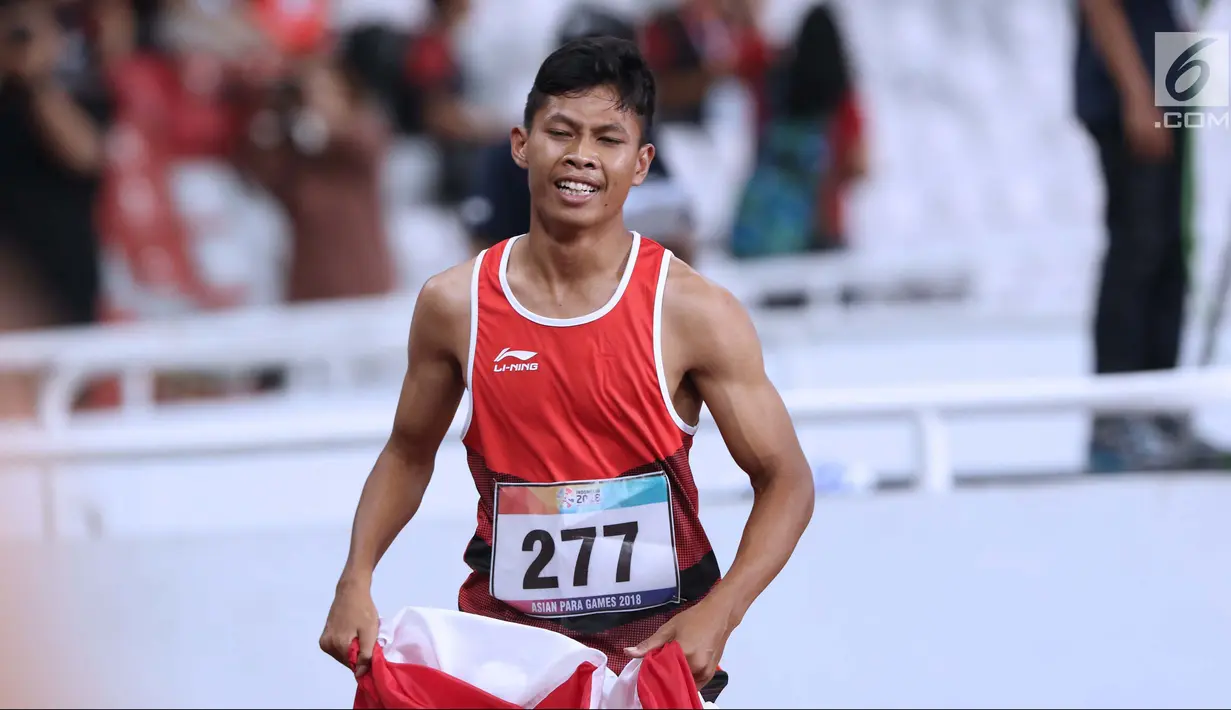 Atlet para-atletik Indonesia, Sapto Yogo Purnomo usai laga lari nomor 100 meter T37 pria yang  digelar di Stadion GBK, Jakarta, Selasa (9/10). Ini menjadi medali emas kedua Sapto di Asian Para Games 2018. (Liputan6.com/Helmi Fithriansyah)