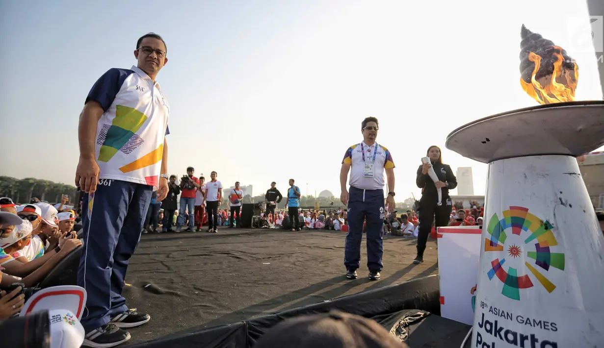 Gubernur DKI Jakarta Anies Baswedan melihat obor Asian Games 2018 di Jakarta, Sabtu (18/8). Anies menjadi pelari pertama yang membawa obor Asian Games 2018 dari Monas. (Liputan6.com/Faizal Fanani)