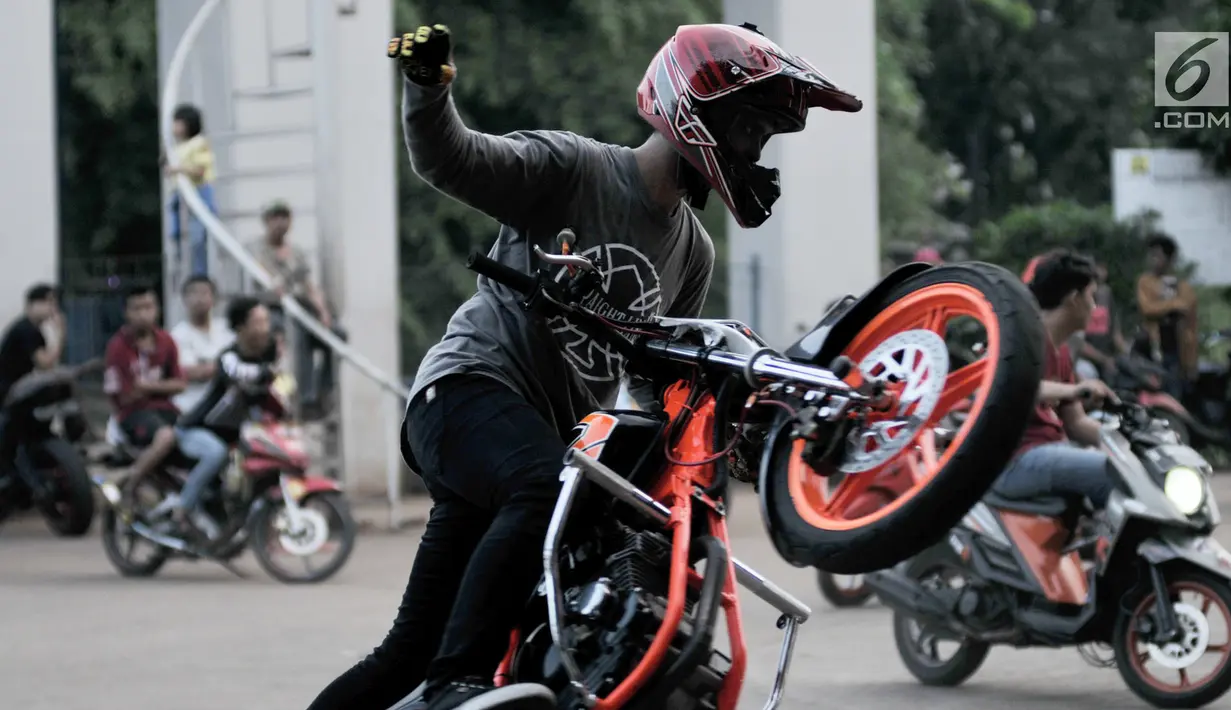 Seorang freestyler motor menunjukkan keahliannya saat meramaikan waktu menjelang berbuka puasa atau ngabuburit di Banjir Kanal Timur (BKT), Jakarta, Minggu (12/5/2019). Aksi para freestyler menari di atas kuda besi menjadi tontonan warga yang sedang ngabuburit di BKT. (merdeka.com/Iqbal Nugroho)