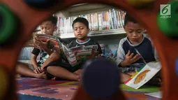 Anak-anak membaca buku di Ruang Perpustakaan RPTRA Kebon Sirih, Jakarta, Kamis (4/4). Gerakan Baca Jakarta dibuat untuk menumbuhkan generasi cerdas yang gemar membaca serta sadar literasi. (Liputan6.com/JohanTallo)
