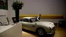 Seorang staf berpose dengan Aston Martin DB5 yang digunakan dalam film James Bond GoldenEye tahun 1995 rumah lelang Bonham, London, Selasa (19/6). Diproduksi mulai 1963 sampai 1965, Aston Martin DB5 bukanlah mobil biasa. (AP/Matt Dunham)