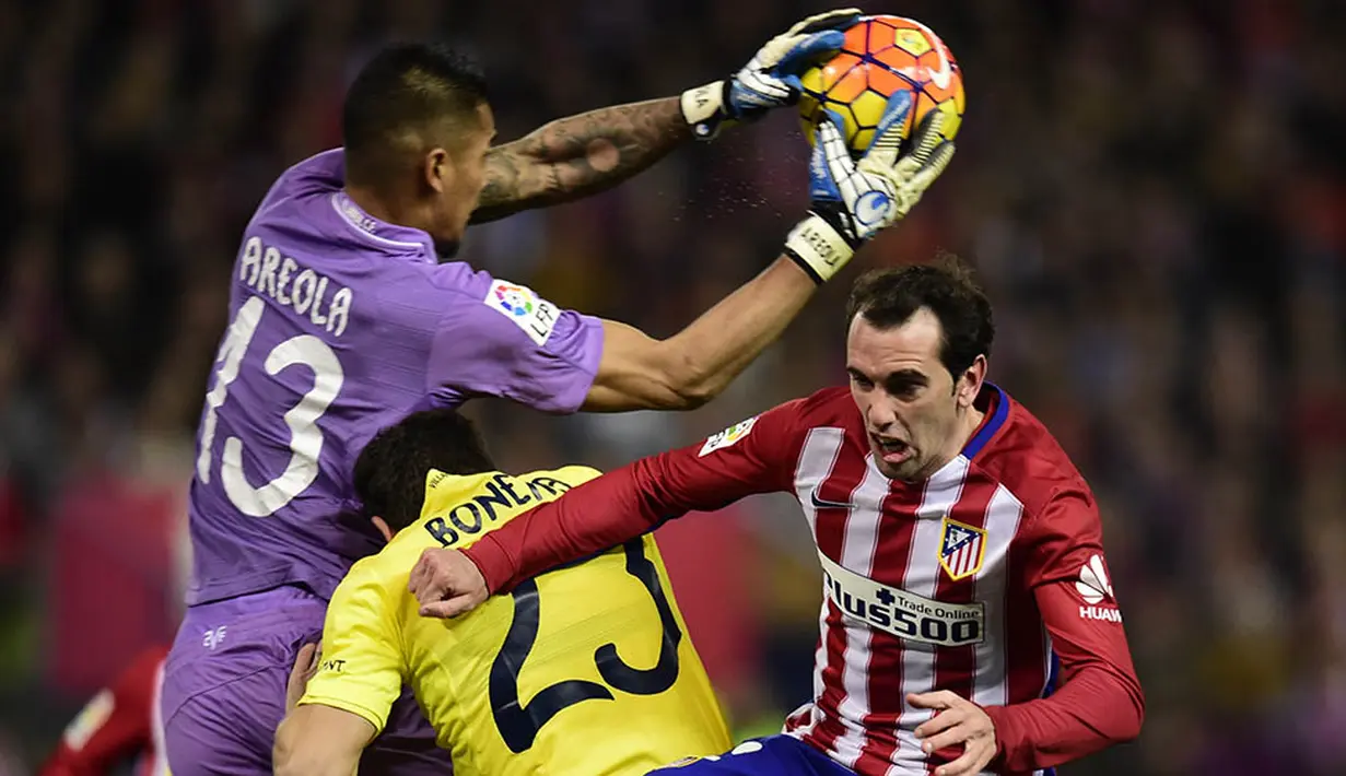 Kiper Villarreal, Alphonse Areola, duel udara dengan bek Atletico Madrid, Diego Godin, pada laga La Liga Spanyol di Stadion Vicente Calderon, Minggu (21/2/2016). Kedua tim bermain imbang 0-0. (AFP/Javier Soriano)