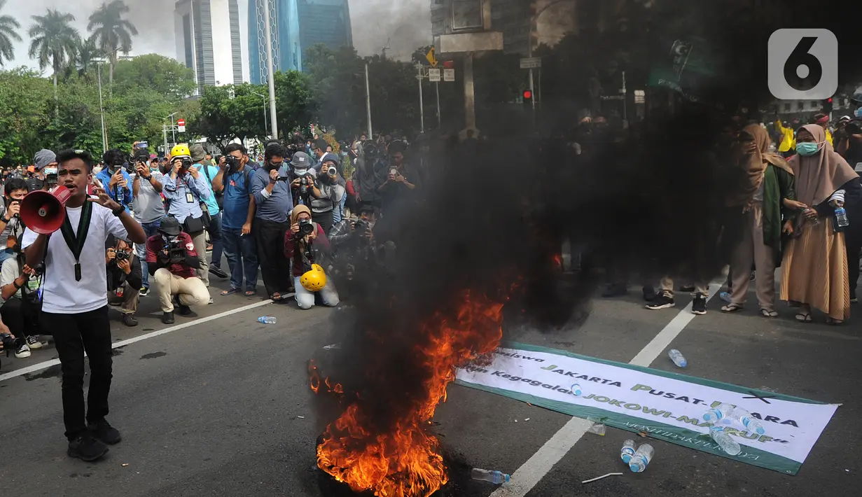Massa Himpunan Mahasiswa melakukan aksi pembakaran ban saat aksi menolak omnibus law sekaligus refleksi satu tahun Pemerintahan Jokowi-Ma'ruf di kawasan Patung Kuda, Jakarta, Selasa (20/20/2020). Aksi ribuan pengunjuk rasa dari berbagai elemn berjalan aman. (merdeka.com/ Arie Basuki)