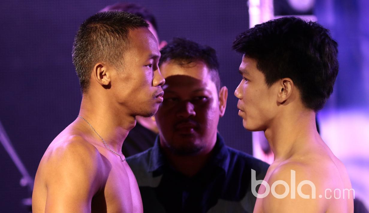 Daud Yordan (kiri) dan Campee Phayom usai melakukan timbang badang pada ajang "Battle of Champions, Road To Glory" di Shanghai Dolly, Singapura, Jumat (24/3/2017).  Daud Yordan dan Campee Phayom akan bermain delapan ronde. (Bola.com/Nicklas Hanoatubun)