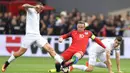 Kapten Inggris, Wayne Rooney, menekel gelandang Slovakia, Marek Hamsik. Pada laga ini Inggris menggunakan formasi 4-3-3, sementara Slovakia menggunakan skema 4-5-1. (AFP/Joe Klamar)