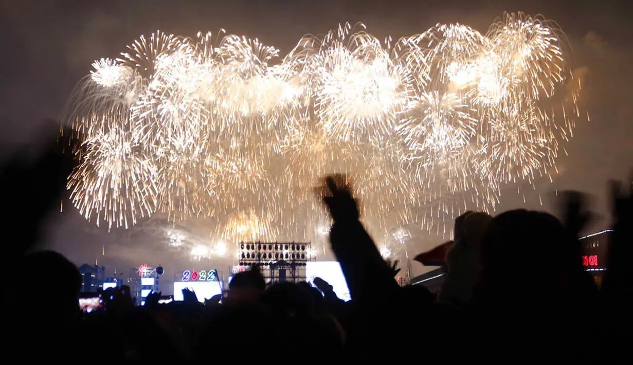 Warga menikmati pertunjukan Tahun Baru di Kim Il-sung Square, Pyongyang, Korea Utara, Sabtu (1/1/2022). Ratusan orang di Pyongyang berkumpul dengan mengenakan masker untuk menyaksikan pertunjukan kembang api menyambut Tahun Baru 2022. (AP Photo/Jon Chol Jin)