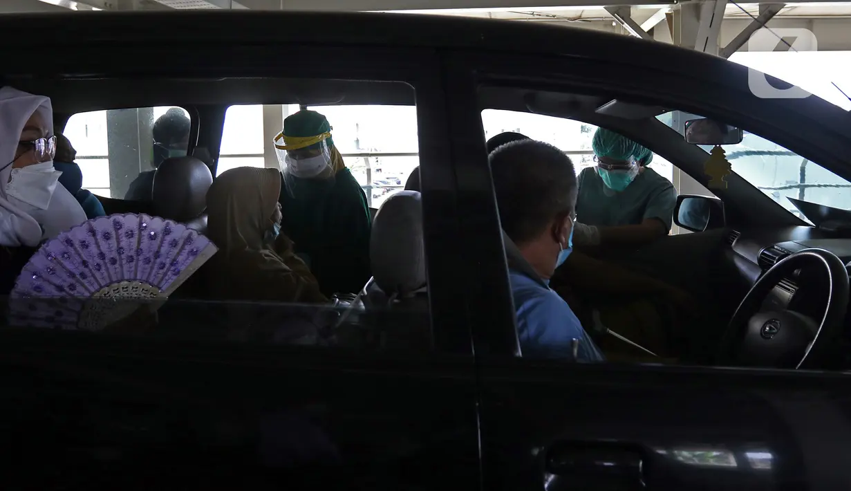 Petugas medis menyuntikkan vaksin COVID-19 kepada lansia secara drive thru di RSUI, Depok, Jawa Barat, Kamis (25/3/2021). Program Sentra Vaksinasi Indonesia Bangkit untuk lansia yang berdomisili di Depok dan sekitarnya ini digelar secara drive thru. (Liputan6.com/Herman Zakharia)