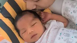 Alinea Ava Nasution tengah terlelap dengan lucunya. Raditya Dika pun tak tahan untuk mencium kepala putri cantiknya tersebut. Memang keberadaan Alinea diharapkan menjadi alinea pembuka yang indah di kehidupan Raditya Dika. (Liputan6.com/IG/@raditya_dika)