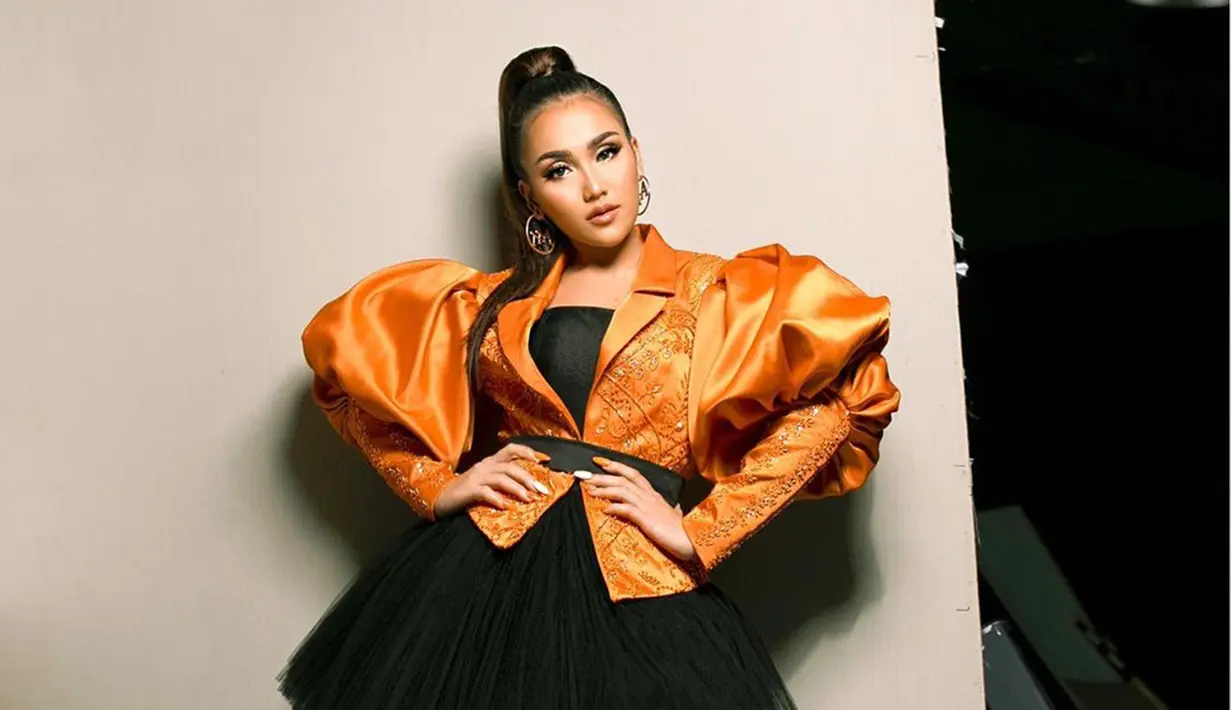 Salah satu gaya rambut yang dinilai cocok dengannya yakni gaya rambut ponytail. Meski simpel hanya dikucir tinggi, pesonanya dengan kostum oranye dan hitam ini membuat dirinya menawan.(Liputan6.com/IG/@ayutingting92)