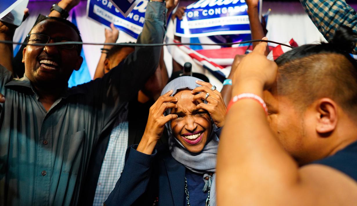 Ilhan Omar bersama pendukungnya merayakan kemenangan putaran pertama pemilihan Distrik Kongres ke-5 di Minneapolis, AS, Selasa (14/8). Wanita 36 tahun kelahiran Somalia ini meninggalkan Tanah Airnya pada 1991. (Mark Vancleave/Star Tribune via AP)
