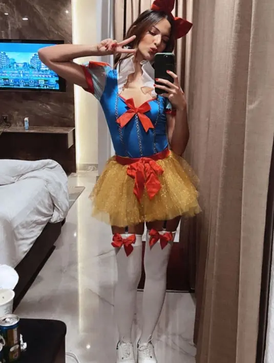Nia Ramadhani tampil dengan mini dress menyerupai putri salju. Dipadukan kaos kaki panjang berpita, lengkap dengan bando pita merah. [@ramadhaniabakrie]