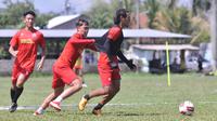 Gelandang Arema, Hanif Sjahbandi ditarik Vikrian Akbar dalam latihan terakhir 30 Oktober lalu di Lapangan Balearjosari, Kota Malang. (Bola.com/Iwan Setiawan)