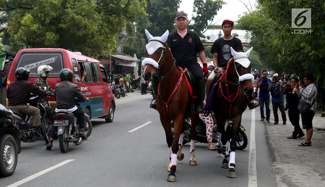 Dua orang pria menunggang kuda di jalan raya untuk persiapan arak-arakan ngunduh mantu Kahiyang-Bobby di Medan, Rabu (22/11). (Liputan6.com/Johan Tallo)
