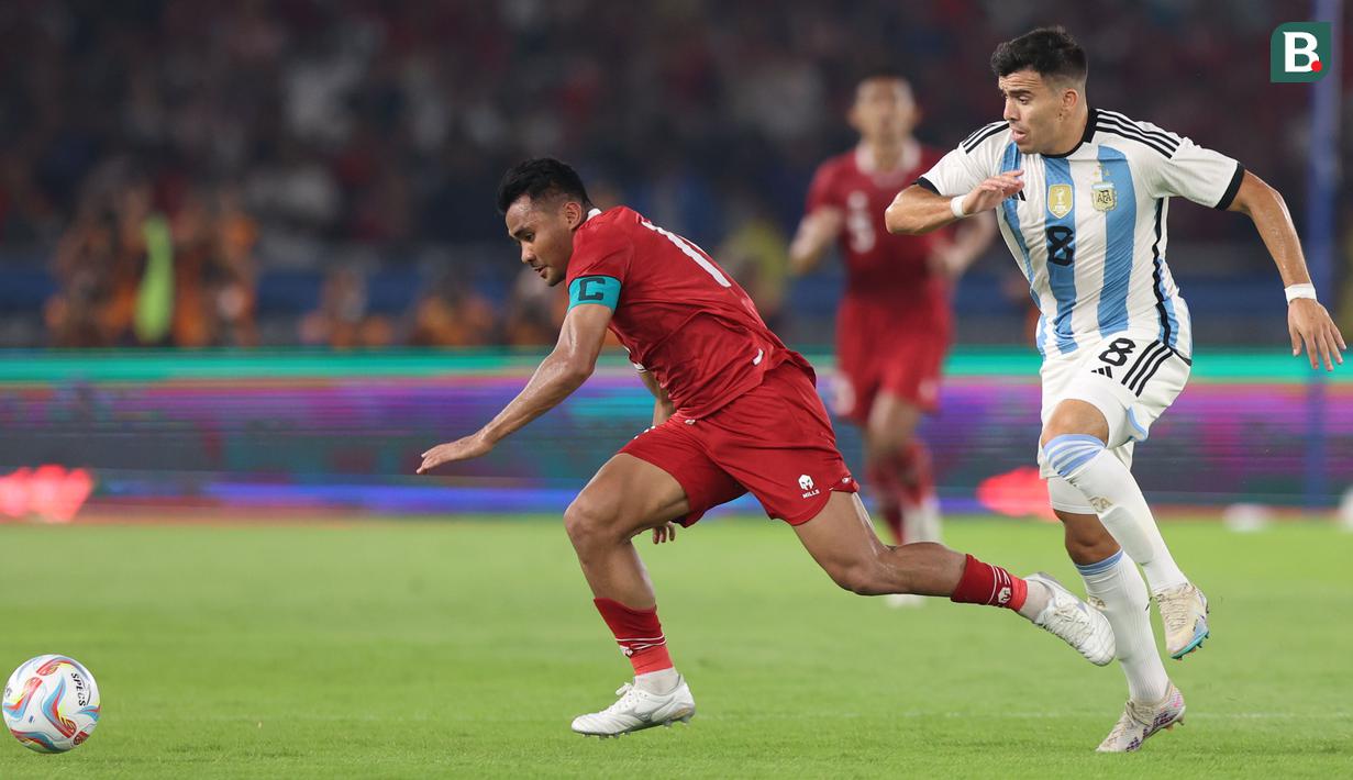 Pemain Timnas Indonesia, Asnawi Mangkualam (kiri) berebut bola dengan pemain Argentina, Marcos Acuna dalam laga FIFA Matchday di Stadion Utama Gelora Bung Karno (SUGBK) Senayan, Jakarta, Senin (19/6/2023). Sang Kapten menjadi kepercayaan Shin Tae-yong dalam dua laga FIFA Matchday dengan membuat 180 menit bermain. (Bola.com/Abdul Aziz)
