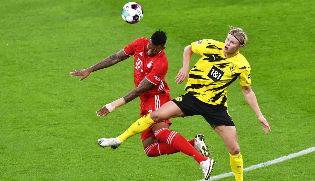 Bek Bayern Munchen, Jerome Boateng, duel udara dengan striker Borussia Dortmund, Erling Haland, pada laga Bundesliga di Stadion Signal Iduna Park, Sabtu (7/11/2020). Bayern menang dengan skor 3-2. (Bernd Thissen/Pool via AP)