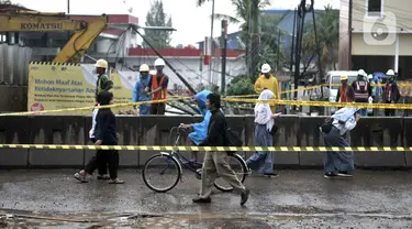 Warga melintasi lokasi semburan gas PGN di proyek Tol Dalam Kota rute Pulogebang-Kelapa Gading, Cakung, Jakarta, Kamis (12/3/2020). Semburan gas yang terjadi sekitar pukul 10.00 WIB tersebut akibat proyek penggalian mengenai pipa distribusi PGN. (merdeka.com/Iqbal Nugroho)