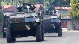 Dua kendaraan militer Filipina (AFV) saat mengambil posisi memerangi militan Maute di kota Marawi, Filipina, (28/5). Sekitar 100 ribu warga Marawi meninggalkan rumahnya akibat pertempuran yang berlangsung. (AP Photo/Bullit Marquez)