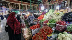 Seorang pembeli mengenakan masker dan sarung tangan lateks, karena pandemi virus corona COVID-19, membeli sayuran selama bulan suci Ramadan di Taheran, Iran (25/4/2020). (AFP/Atta Kenare)