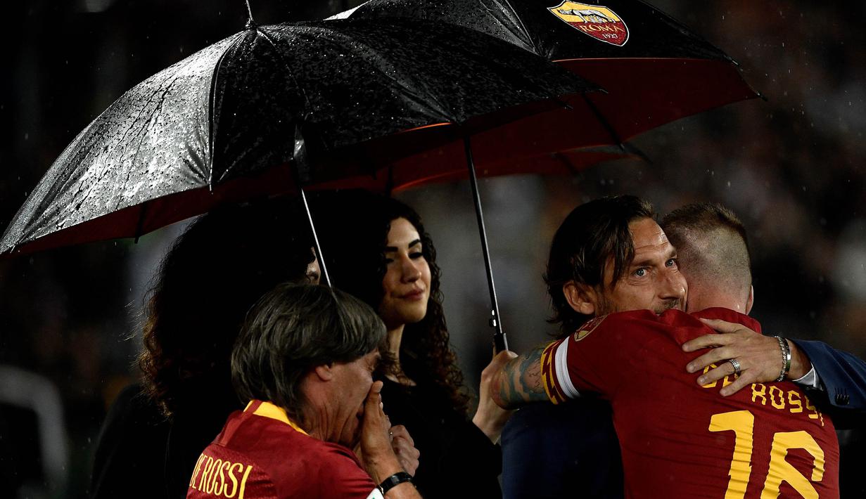 Gelandang AS Roma, Daniele De Rossi, bersama Francesco Totti usai melawan Parma pada laga Serie A di Stadion Olympic, Roma, Minggu (26/5). Laga ini perpisahan bagi De Rossi dan AS Roma setelah 18 tahun. (AFP/Filippo Monteforte)