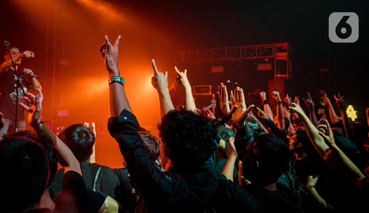 Para penonton berjoget bersama saat menyaksikan salah satu band metal dalam konser offline di kawasan Jakarta, Minggu (22/5/2022). Konser musik offline kembali diizinkan seiring dengan pelonggaran aturan penggunaan masker di luar ruangan. (Liputan6.com/Faizal Fanani)