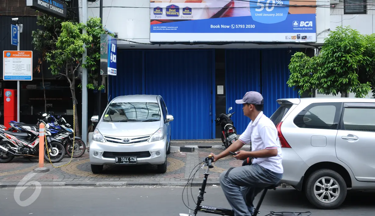 Pengendara sepeda melintas di depan sebuah bank yang ditutup di Jalan Agus Salim Jakarta, Kamis (14/1). Pasca ledakan di pos polisi dekat Gedung Sarinah, sejumlah toko dan kantor di sekitar lokasi berhenti beroperasi.  (Liputan6.com/Helmi Fithriansyah)
