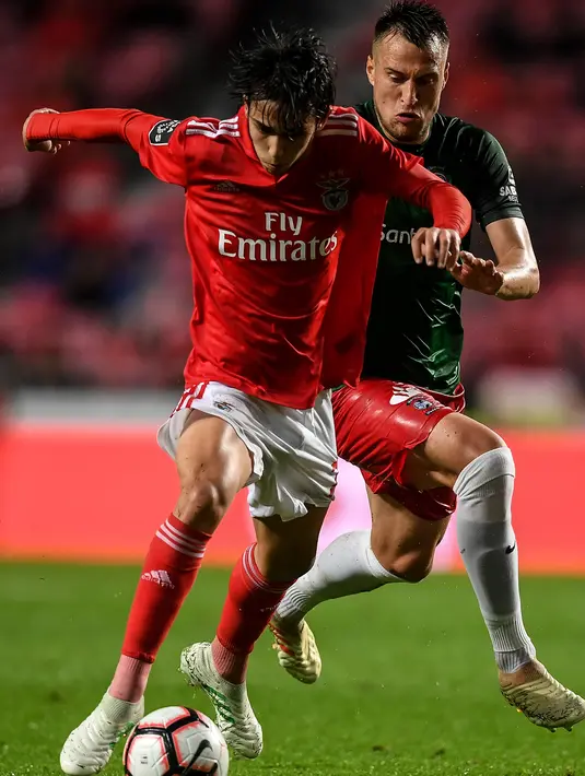 Gelandang Benfica, Joao Felix menggiring bola dari kejaran gelandang CS Maritimo, Josip Vukovic selama pertandingan Liga Portugal di stadion Luz pada 22 April 2019. Joax Felix memulai karier di Os Pestinhas pada 2007, sebelum pindah ke Porto dua bulan kemudian. (AFP Photo/Patricia De Melo Moreira)