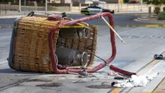 Keranjang balon udara yang jatuh tergeletak di trotoar di Albuquerque, New Mexico, Amerika Serikat, Sabtu (26/6/2021). Polisi mengatakan lima penumpang tewas setelah jatuh di jalan yang ramai. (AP Photo/Andres Leighton)