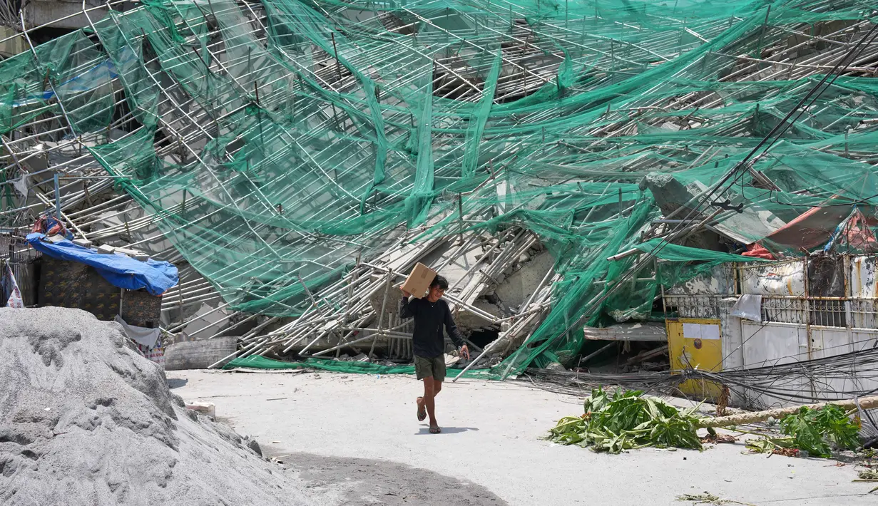 Seorang pria melewati bangunan yang runtuh di kota Angeles, provinsi Pampanga, utara Manila, Filipina, Senin 25 Mei 2026. (AP Photo/Aaron Favila)