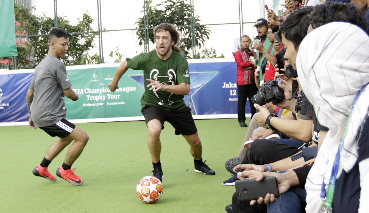 Legenda Barcelona, Carles Puyol, menggiring bola saat bermain futsal di Lapangan Menara Imperium, Jakarta, Selasa (12/3). Pertandingan tersebut merupakan bagian dari kegiatan UEFA Champions League Trophy Tour di Jakarta. (Bola.com/M Iqbal Ichsan)