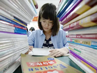 Seorang siswi sekolah menengah mengerjakan soal menjelang ujian tahunan "Gaokao" atau ujian masuk perguruan tinggi di China, Handan, provinsi Hebei Utara (23/5). Gaokao China akan berlangsung 7-8 Juni tahun ini. (AFP Photo/China Out)