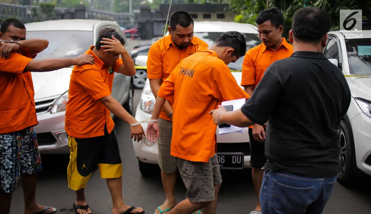 Polisi menunjukkan tersangka berikut barang bukti mobil saat ungkap kasus penipuan dan penggelapan di Polda Metro Jaya, Rabu (18/9/2019). Subdit 6 Ditreskrimum PMJ mengungkap kejahatan penggelapan mobil dengan barang bukti 28 kendaraan roda empat dan sejumlah tersangka. (Liputan6.com/Faizal Fanani)