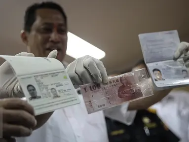 Kepala BNN Komjen Budi Waseso menunjukan barang bukti paspor yang digunakan pelaku saat rilis barang bukti sabu di Gedung BNN, Jakarta, Rabu (20/4). BNN berhasil membongkar sindikat sabu international. (Liputan6.com/Faizal Fanani)