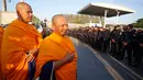  Dua Biksu berdiri di depan petugas saat melakukan penggeledahan Kuil Dhammakaya, Pathum Thani, Thailand (17/2). Kuil terbesar di Thailand ini digeledah untuk mencari biksu Phra Dhammachayo karena dakwaan pencucian uang. (AP Photo / Sakchai Lalit)