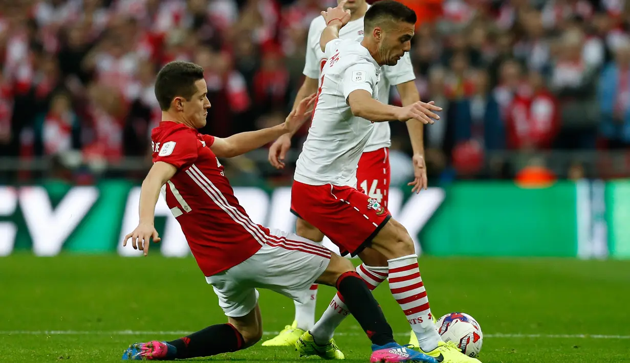 Gelandang Manchester United, Ander Herrera berusaha merebut bola gelandang Southampton, Dusan Tadic pada final Piala Liga Inggris di Stadion Wembley, London, (27/2). MU menang atas Southampton dengan skor 3-2. (AFP Photo / Ian Kington)