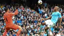 Pemain Manchester City, Vincent Kompany (kanan) mencoba mengecoh kiper Swansea City, Lukasz Fabianski pada lanjutan Premier League di Etihad Stadium, Manchester, (22/4/2018). Manchester City menang 5-1. (AFP/Paul Ellis)