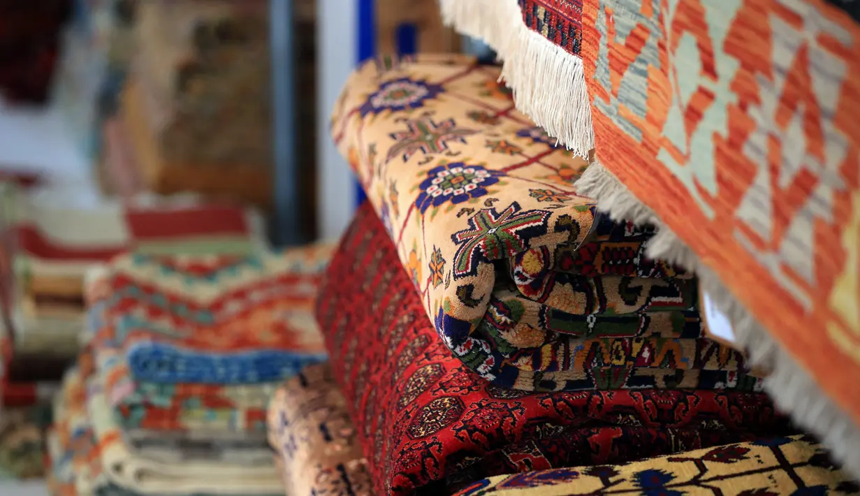 Tumpukan karpet Afghanistan dijual di The Afghan Rug Shop, Hebden Bridge, Inggris, 20 Agustus 2021. Pemilik The Afghan Rug Shop James Wilthew membeli karpet yang dicari langsung dari provinsi utara, di mana industri ini secara tradisional berbasis. (LINDSEY PARNABY/AFP)