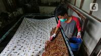 Perajin mewarnai kain batik di rumah produksi batik tanah liek Ayesha Collection di Padang, Sumatera Barat, Kamis (25/11/2021). Batik tanah liek Ayesha yang merupakan UMKM Binaan PT Semen Padang (Semen Indonesia Group) dijual mulai Rp250 ribu hingga jutaan rupiah. (Liputan6.com/Fery Pradolo)