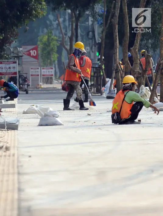 Sejumlah pekerja melakukan pengerjaan tahap akhir renovasi trotoar di sekitar Jalan Gerbang Pemuda, Senayan, Jakarta, Selasa (29/5). Renovasi sebagai bagian persiapan pelaksanaan Asian Games 2018. (Liputan6.com/Helmi Fithriansyah)