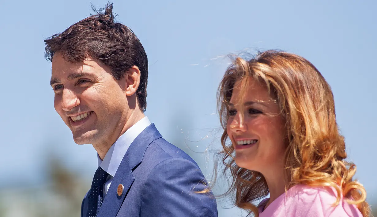 File foto 8 Juni 2018, PM Kanada Justin Trudeau dan istrinya Sophie Gregorie Trudeau tiba untuk upacara penyambutan bagi para pemimpin G7 pada hari pertama KTT di Quebec. Kantor pemerintahan mengonfirmasi istri PM Justin Trudeau dinyatakan positif terinfeksi Virus Corona COVID-19. (GEOFF ROBINS/AFP)