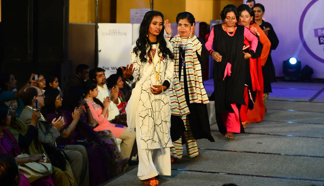 Wanita korban serangan cairan asam berjalan di atas catwalk pada pagelaran busana bertajuk "Beauty Redefined" di Dhaka, Bangladesh, 7 Maret 2017.  Tujuan dari peragaan busana ini adalah menumbuhkan pemahaman warga terhadap kejahatan cairan asam. (STR/AFP)