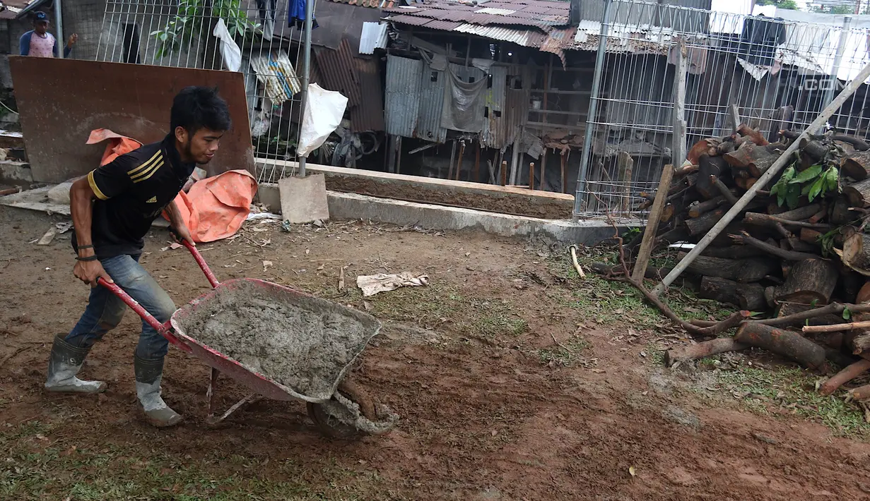 Pekerja Dinas Sumber Daya Air Jaksel memperbaiki turap di tepi Ruang Publik Terpadu Ramah Anak (RPTRA) Tiga Durian, Jakarta, Kamis, (22/2). Perbaikan dilakukan usai longsor pekan lalu, Kamis (15/2). (Liputan6.com/Immanuel Antonius)