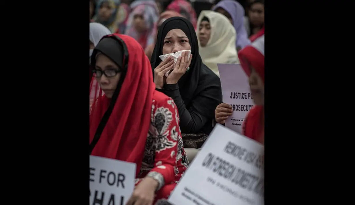 Dalam doa yang digelar di Taman Victoria, Hong Kong tersebut, beberapa TKI menangis mengenang kematian Sumarti Ningsih dan Seneng Mujiasih, Minggu (9/11/2014). (AFP PHOTO/Philippe Lopez)