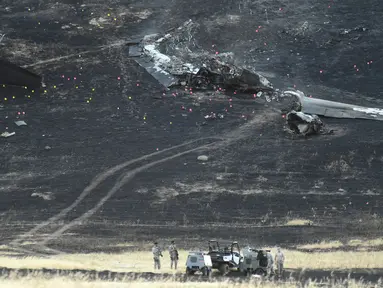 Anggota militer menyelidiki lokasi jatuhnya pesawat mata-mata Amerika Serikat U-2 "Dragon Lady" ketika menjalani sesi latihan di Sutter, California, Selasa (20/9). Seorang pilot tewas sementara satu lainnya cedera akibat kecelakaan itu. (JOSH Edelson/AFP)