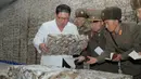 Gambar tak bertanggal yang dirilis pada 19 November 2019, pemimpin Korea Utara Kim Jong-un (kiri) mengunjungi pabrik pengolahan ikan di lokasi yang dirahasiakan di Korea Utara. Kim Jong-un berbicara dengan para pekerja dan sesekali tertawa saat berkeliling pabrik.  STRINGER/KCNA VIA KNS/AFP)