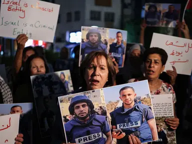 Para demonstran memegang foto dan spanduk yang mengecam pembunuhan jurnalis Al Jazeera dalam serangan Israel di Kota Gaza, selama aksi doa bersama di Ramallah, di Tepi Barat yang diduduki pada 11 Agustus 2025. (Zain JAAFAR/AFP)