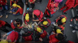 Buruh beristirahat sambil makan siang disela aksi demo di kawasan Istana Negara, Jakarta, Kamis (15/9). Ribuan buruh dari berbagai elemen organisasi menyatakan penolakan mereka terhadap paket kebijakan ekonomi jilid IV. (Liputan6.com/Faizal Fanani)