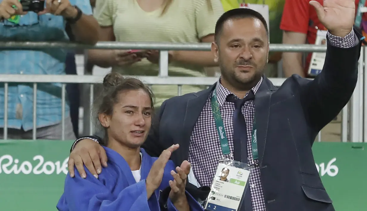 Atlet Kosovo, Majlinda Kelmendi  merayakan kemenangannya setelah memenangkan medali emas pada cabang judo putri Olimpiade 2016 di Rio de Janeiro, Minggu (7/8). Kelmendi menjadi atlet pertama dari Kosovo yang meraih medali Olimpiade. (Jack GUEZ/AFP)