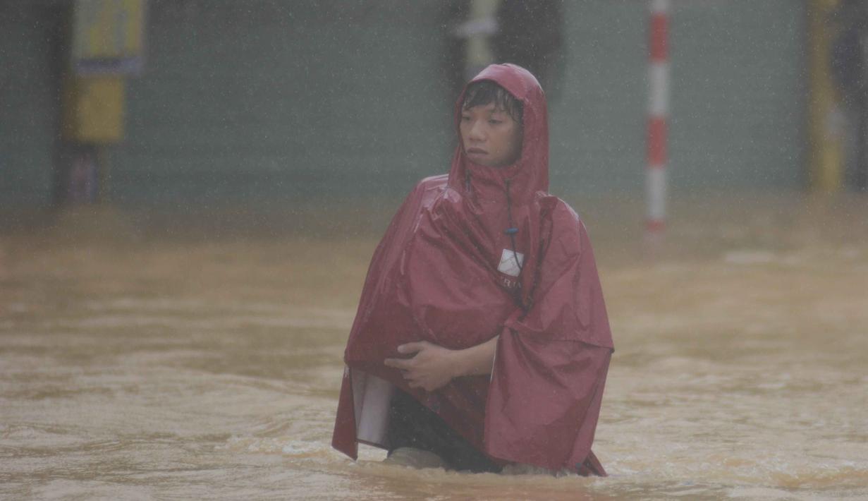 Seorang pria mengarungi jalan yang terendam banjir di Hue, Vietnam, Selasa, 28 Oktober 2025. Kementerian Lingkungan Hidup Vietnam pada Selasa (28/10/2025) mengatakan, tiga stasiun pengamatan di Kota Hue mencatat curah hujan antara 1.000 hingga 1.700 milimeter dalam periode 24 jam dari Minggu (26/10) hingga Senin (27/10/2025). (Van Dung/VNA via AP)