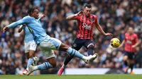 Bek Manchester City, Manuel Akanji (kiri) melepaskan tekel kepada penyerang Everton, Jack Harrison dalam laga lanjutan Premier League 2023/2024 di Etihad Stadium, Sabtu (10/2/2024) malam WIB. (AFP/Darren Staples)