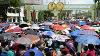 Ribuan warga rela menunggu kadatangan Sultan Hassanal Bolkiah dan Ratu Saleha Brunei pada prosesi Golden Jubilee di Bandar Seri Begawan (5/10). Perayaan tersebut menandai 50 tahun bertahta. (AFP PHOTO / Roslan Rahman)